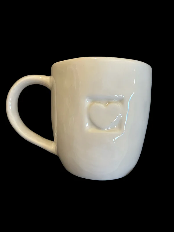 The Heart Impression Mug is shown. It is a white mug with a small impression of a heart on it.