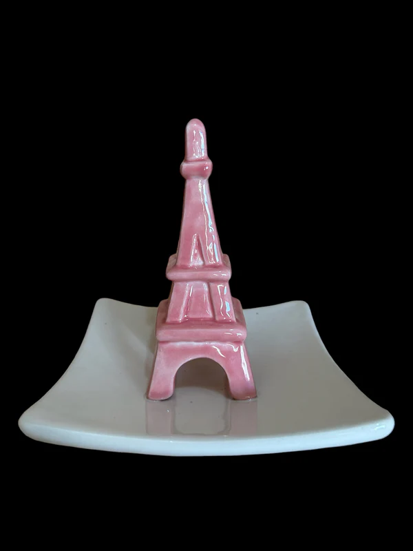 The Eiffel Tower Ring Holder (Square Base) is shown. It is a ceramic Eiffel tower painted pink and attached to a white square base.
